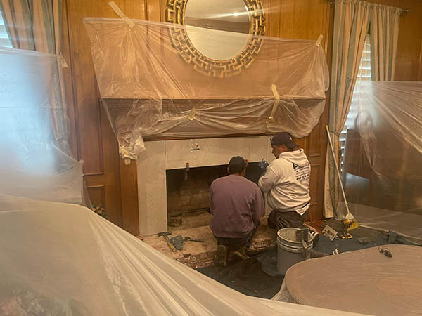 Fireplace contractors working in chimney indoors.