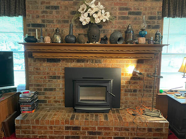 red brick chimney with wood mantle