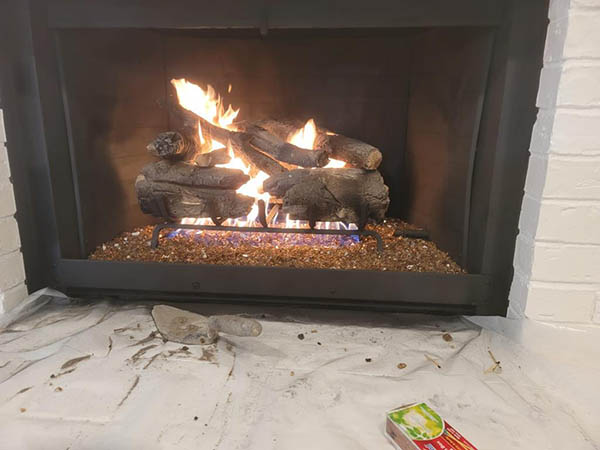 Gas log fireplace with lit fire